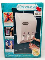 Close-up photo of the dispenser on packaging showing push-button labeled compartments and dispenser logo.