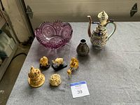 Lot of seven vintage Asian inspired items including amethyst crystal bowl, painted China ceramic piece, silver plate vase, and five ivory figurines displayed on gray fabric.