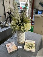 Photo of two wedding planning books and a white floral centerpiece on a table.