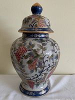 Full view of oval ginger jar with lid showing the overall design, colors, and crackle glaze.