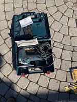 Open case showing jigsaw, cord, and manual