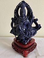 Front view of the lapis lazuli seated Buddhist figure on stand