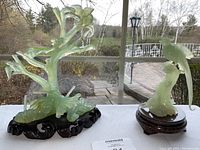 Overall view of both carved stone figurines on wood stands