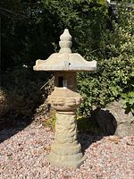 Full front view of entire statue showing base, column, lantern, roof and finial