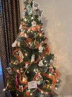 Full view of 36-inch artificial Christmas tree with owl-themed ornaments, orange ribbon, and glowing lights.