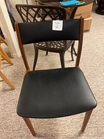 Front view of Danish office chair with black seat and backrest, wooden legs and frame