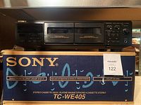Front view of Sony TC-WE405 twin stereo cassette deck on top of its original box showing two cassette compartments and control panel.