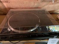 Front angle of the JVC L-FX4 turntable with dust cover closed, showing the full unit and controls.