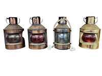 Front view of all four brass boat lanterns showing two port side red lanterns, one starboard or masthead lantern with a clear lens, and one masthead lantern with red lens and rope handle.