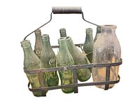 Metal milk bottle carrier loaded with 8 green Coca-Cola glass bottles and 1 clear Ipswich milk bottle on a white background.