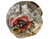 Photo of a large jar filled with assorted colorful beads, costume jewelry parts, and findings.