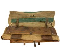 Top view showing canvas flap with "U.S." marking, green trim, leather straps and buckles.