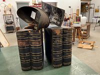 Viewer positioned before four bound volumes labeled United States Vol. I & II and Tour of the World Vol. I & II