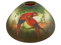 Front view of reverse painted lampshade showing two red parrots on a branch with green foliage.