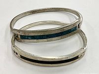 Two pairs of vintage sterling silver bracelets, one pair featuring turquoise mosaic stone inlay, shown stacked.