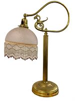 Front angled view of vintage brass desk lamp with pink glass shade and beaded fringe, dragon scroll detail on arm visible.