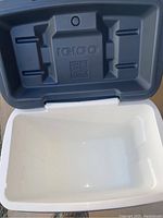 Open cooler showing clean white interior with embossed Igloo logo on lid.