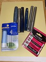 Lot layout showing all lip products including Nivea lip balm pack, loose Nivea stick, Chap Stick 3-pack, and assorted lipsticks and lip glosses