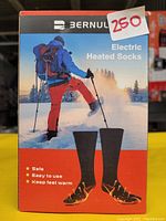 Box front showing the Bernur Electric Heated Socks package with image of hiker wearing heated socks. Box states 'Safe, Easy to use, Keep feet warm'. Sticker labeled 250.