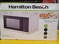 Photo of original product box showing Hamilton Beach microwave oven image, specifications, and features.