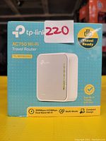 Photo of TP-Link AC750 Wi-Fi Travel Router TL-WR902AC box showing front design and key features.