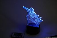 LED Spider-Man 3D optical illusion lamp lit in blue with remote on the side