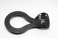 Photo showing side view of black plastic ring-shaped ring light designed to fit flashlight with strap holder.