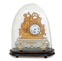 Assembled clock under glass dome on wooden pedestal