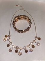 Photo of morganite and citrine necklace with matching bracelet on a flat surface showing the design and color of stones.