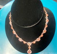 Front view of smoked topaz and crystal necklace displayed on black velvet bust, highlighting the teardrop pendant and round stones.
