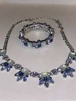Photo showing the topaz and moonstone necklace and bracelet set laid flat on a surface.