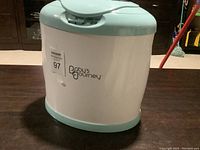 Front and side view of the Baby's Journey towel warmer showing brand name and compact design.