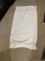 Single large white towel laid flat showing size and texture.