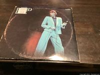 Front cover of the David Bowie Live double album LP record showing Bowie in a blue suit on stage. The cover shows wear on the edges.