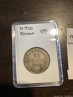 Reverse side of the 1918 Newfoundland 50 cent coin showing denomination and date in plastic capsule.