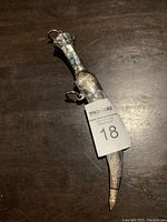 Photo of the sheathed Persian jambiya dagger showing abalone inlay handle and patterned metal sheath.