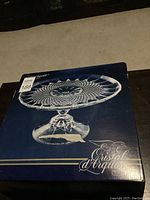 Original box with image and branding showing the Cristal d'Arques Longchamp round cake stand.