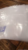 Photo of stacked clear 9-pocket trading card pages with individual pockets visible and glossy finish, showing Polygard brand mark.