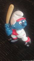Front right angle view showing Smurf figure holding baseball bat ready to swing.