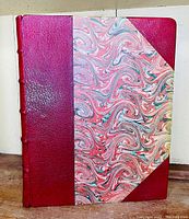 Front cover of the book showing dark red leather and colorful marbled paper binding.
