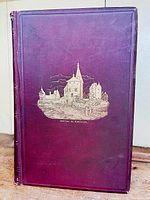 Front cover of burgundy hardbound book with gold embossed Château de Montaigne illustration.