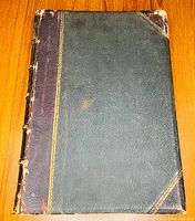 Top cover showing half leather binding, gilt spine decoration and wear at corners.