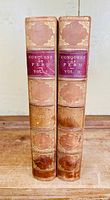 Two volumes of Conquest of Peru by William H. Prescott showing leather spines with gilt embossing and red leather title labels.