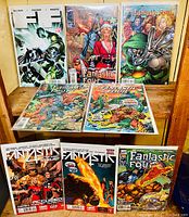 Photo showing all eight Fantastic Four comic books arranged on a wooden surface, showcasing their front covers
