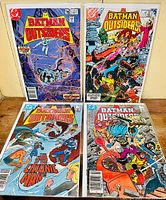 Four Batman and the Outsiders comic books displayed together, showing front cover art of each. The comics are bagged and boarded, standing upright.