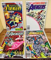Four Marvel Comics Avengers issues displayed upright showing cover art.