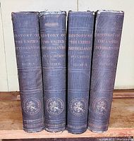 Four books in a set, showing dark cloth covered spines with faded gilt text 'History of the United Netherlands by J.L. Motley, Volumes I-IV' and publisher's emblem at bottom of each spine.