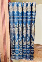 Spines of six blue cloth hardcover volumes with gilt decoration and volume numbering