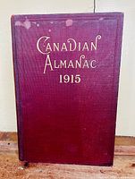 Front cover of 'Canadian Almanac 1915' showing burgundy cover with gold embossed title and slight discoloration marks.