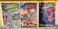 Front view of three Flash Gordon comics in protective covers, showing vibrant covers with sci-fi action scenes.